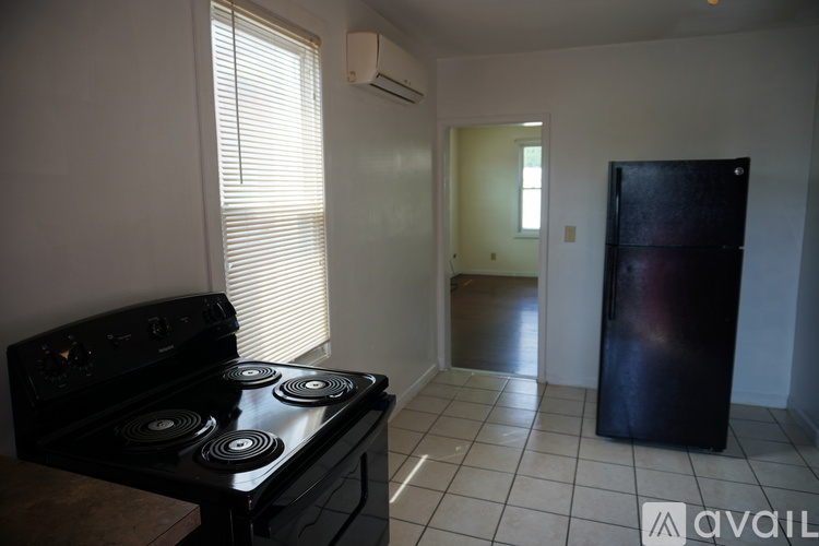 A white refrigerator in a kitchen with a fan on the ceiling.