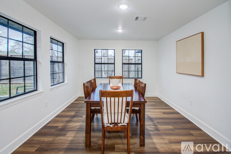 A dining room with a wooden table and chairs.