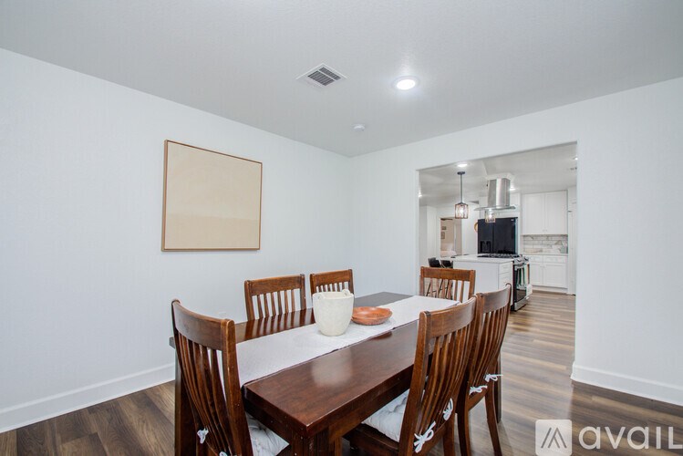 A dining room with a wooden table and chairs.