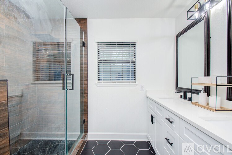A bathroom with a walk-in shower and a vanity with a mirror.