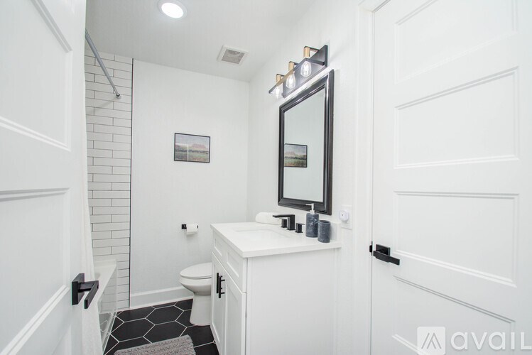 A white bathroom with a mirror and a toilet.