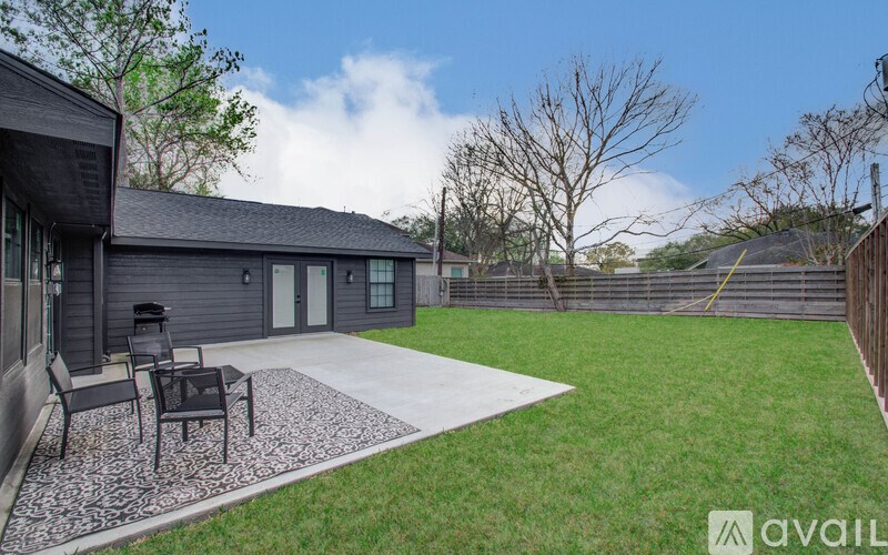 A backyard with a patio and a black chair.