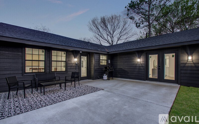 A black house with a patio and chairs.