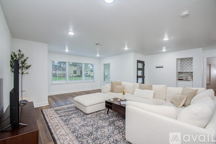 A living room with a white couch and a rug.