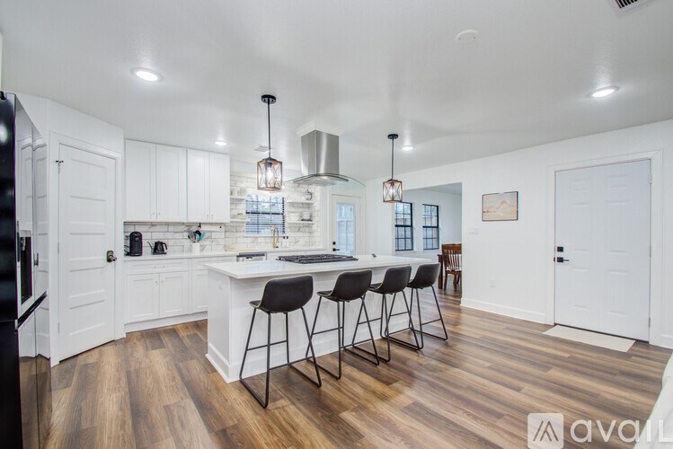 A kitchen with white cabinets and a wooden floor.