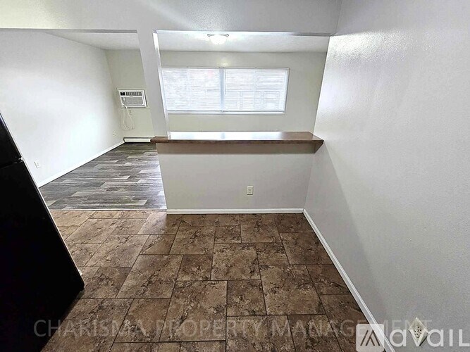 A room with a brown tiled floor and white walls.