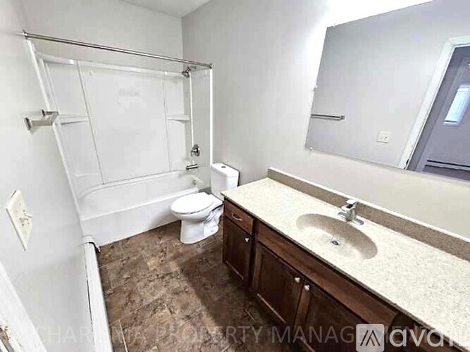 A bathroom with a toilet, sink, and shower.