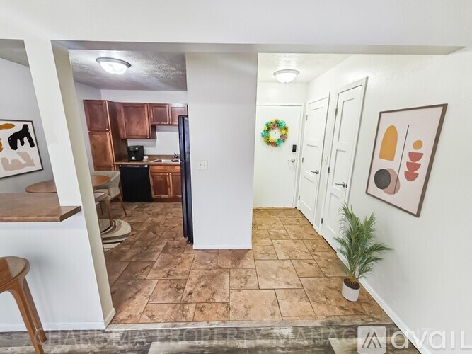 A kitchen with a black refrigerator and a wreath on the door.