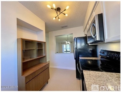 A kitchen with a black stove top oven and a black microwave above it.