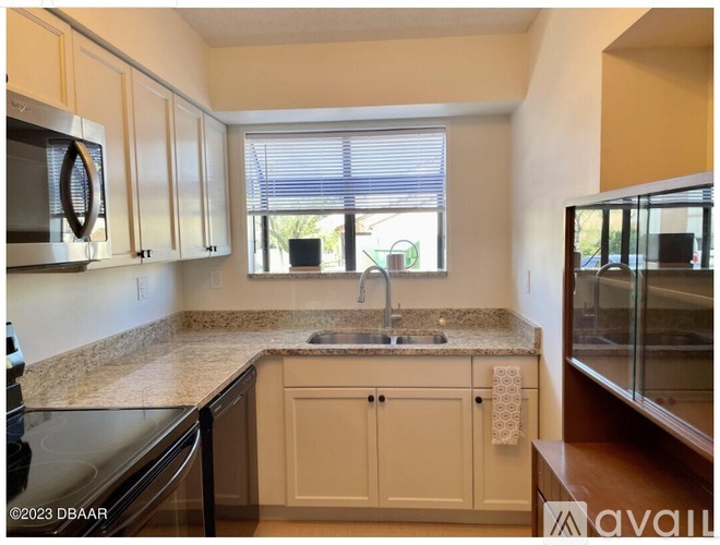 A kitchen with a granite countertop and white cabinets.