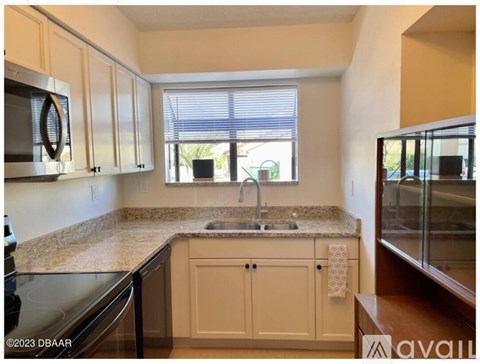 A kitchen with a granite countertop and white cabinets.