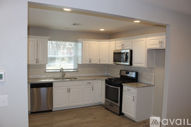 A kitchen with white cabinets and a stainless steel dishwasher.