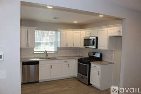 A kitchen with white cabinets and a stainless steel dishwasher.