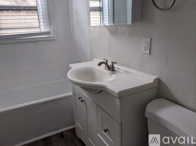 A white bathroom sink with a cabinet below it.