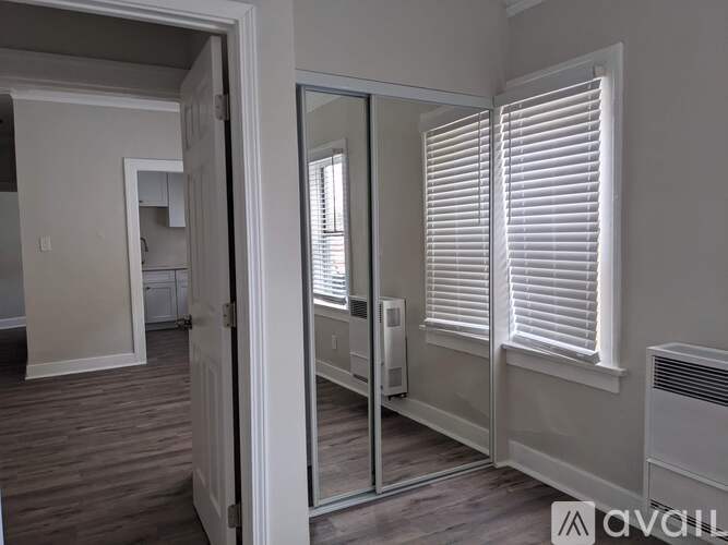 A room with a sliding glass door and a window with blinds.