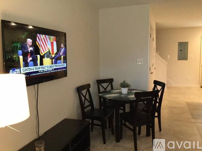A living room with a television showing Clinton and Trump on screen.