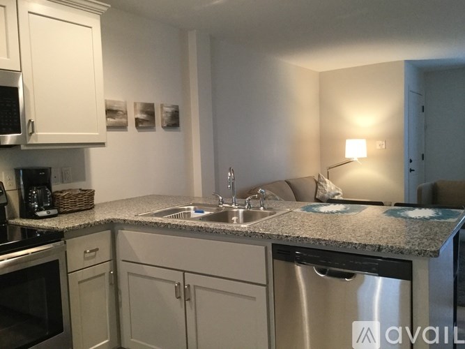 A kitchen with a granite countertop and stainless steel appliances.
