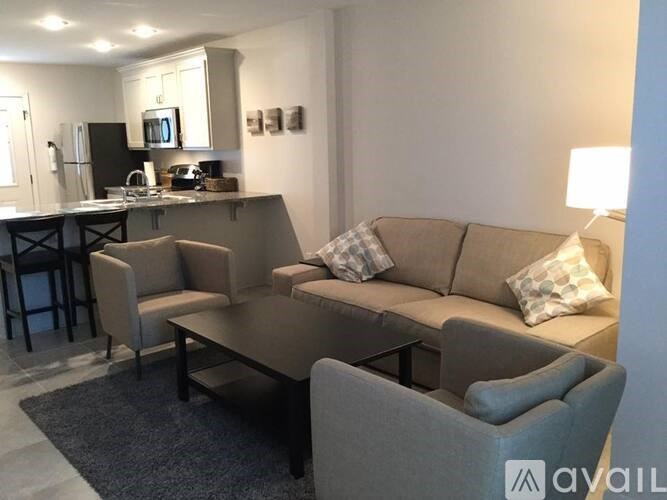 A modern living room with a grey couch and a black coffee table.
