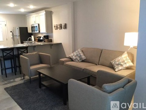 A modern living room with a grey couch and a black coffee table.
