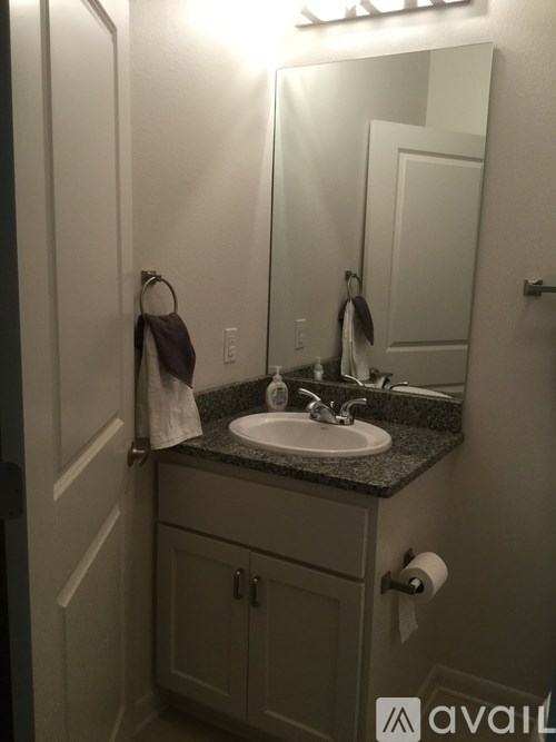 A bathroom with a sink, mirror, and cabinets.