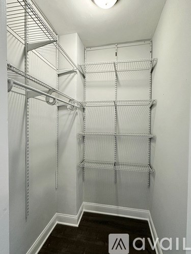 A white walk in closet with shelves and hangers.