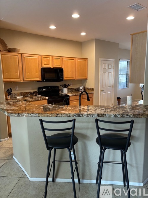 A kitchen with granite countertops and wooden cabinets.