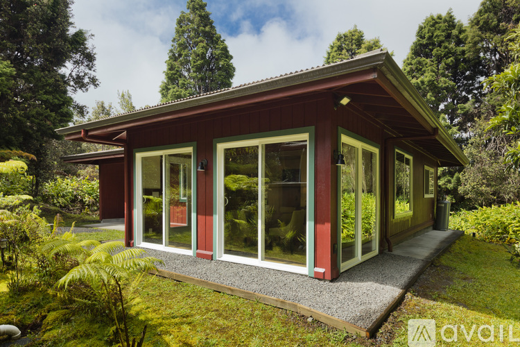A red house with a green roof and glass doors.