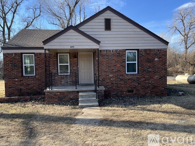 A brick house with a white door and windows.