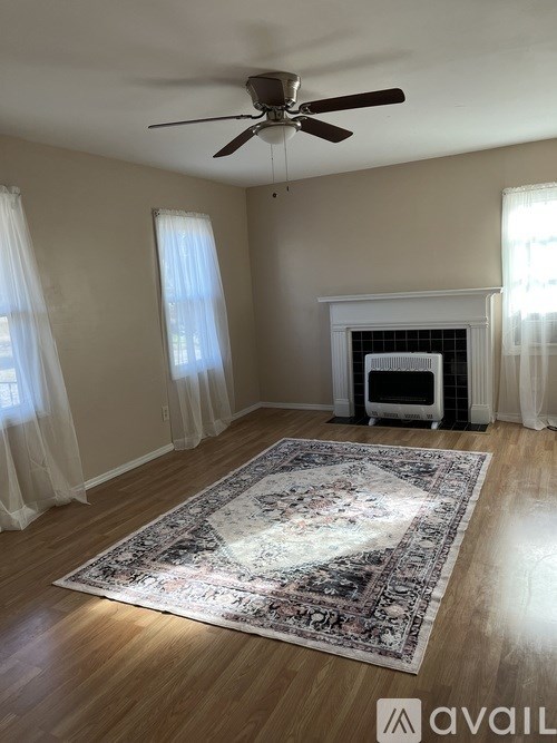 A room with a fireplace and a rug on the floor.