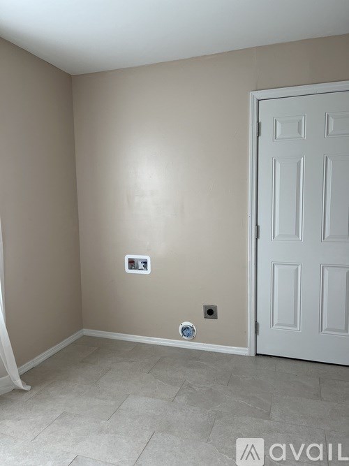 A room with a white door and a tiled floor.