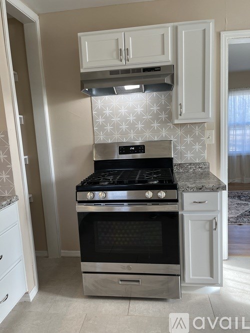 A kitchen with a stove and a tiled backsplash.