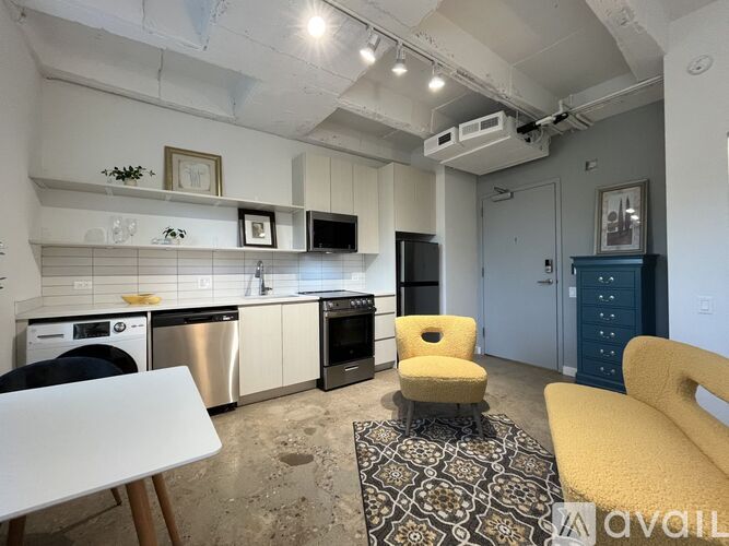 A kitchen with a white table and yellow chairs.