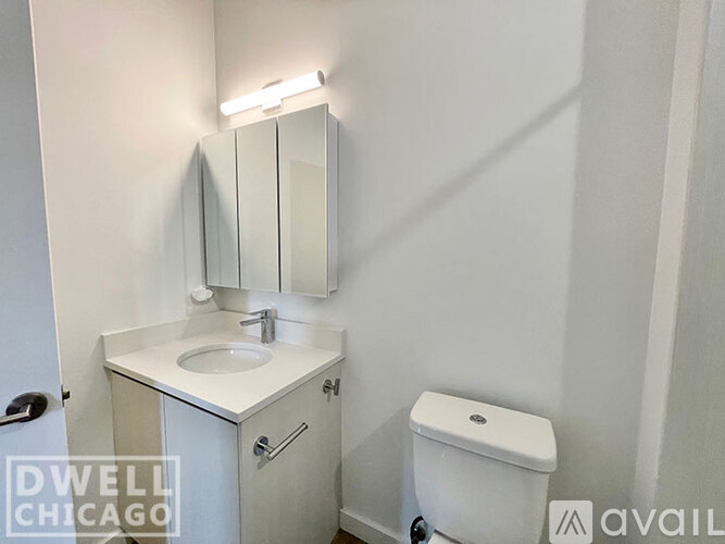 A small white bathroom with a sink, toilet and mirror.