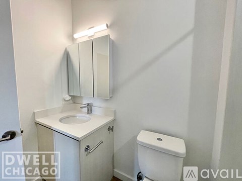 A small white bathroom with a sink, toilet and mirror.