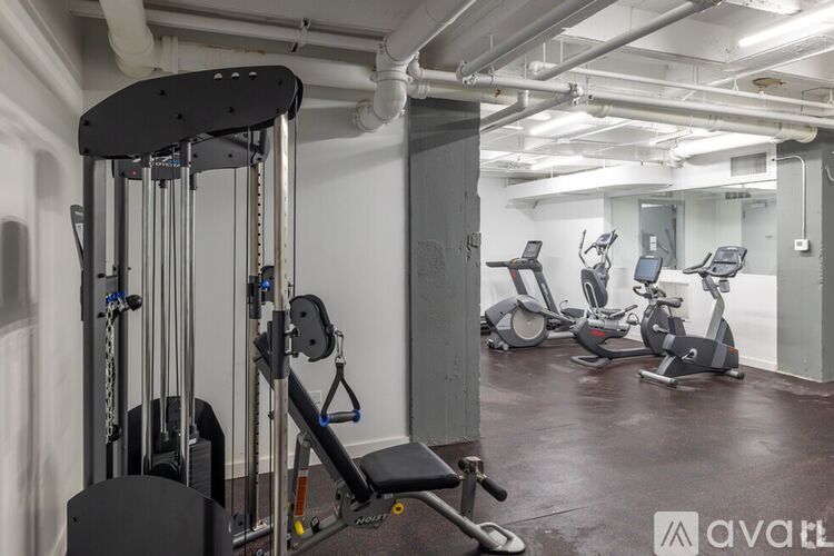 A gym with a variety of equipment including treadmills, weights, and exercise machines.