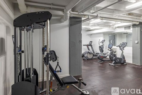 A gym with a variety of equipment including treadmills, weights, and exercise machines.