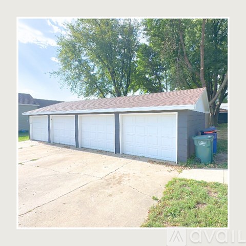 A two-car garage with a brown roof and white doors.