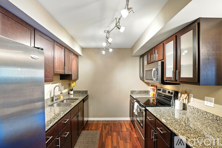 A kitchen with brown cabinets and granite countertops.