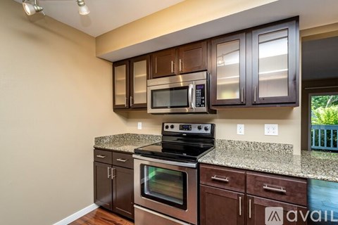 A kitchen with brown cabinets and granite countertops.