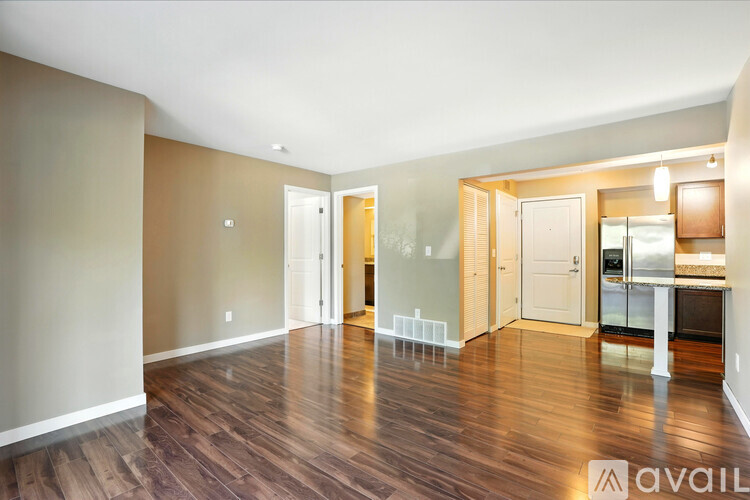 A kitchen with a refrigerator, cabinets, and a bed.
