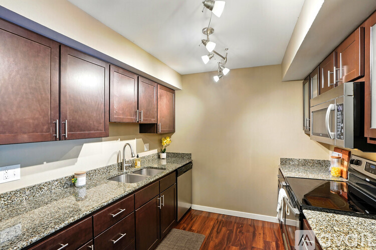 A spacious room with wooden floors and sliding glass doors leading to a balcony.