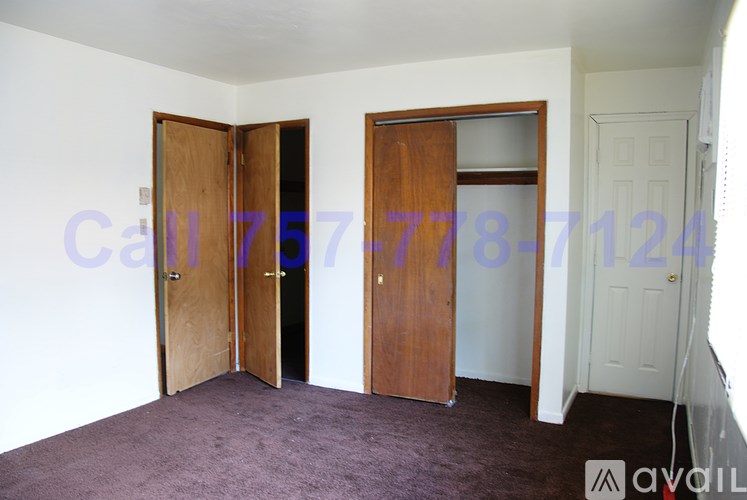 A room with two open doors and a white door on the right.