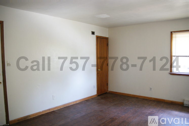 A room with a door and a window, and a phone number is written on the wall.