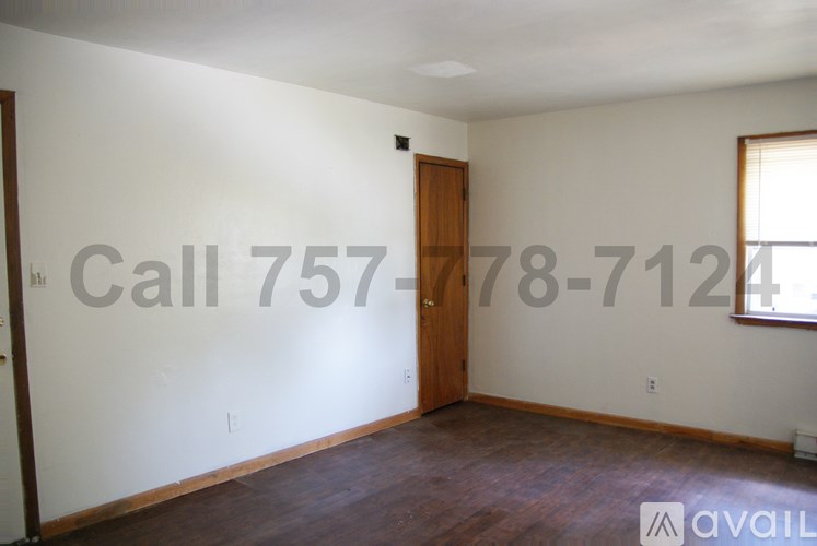 A room with a door and a window, and a phone number is written on the wall.