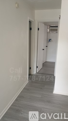 A room with a door and a window, and a phone number is written on the wall.