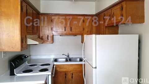 A kitchen with wooden cabinets and a white fridge.