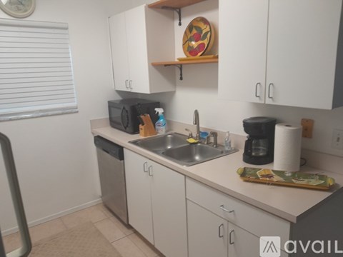 A kitchen with white cabinets and a sink.