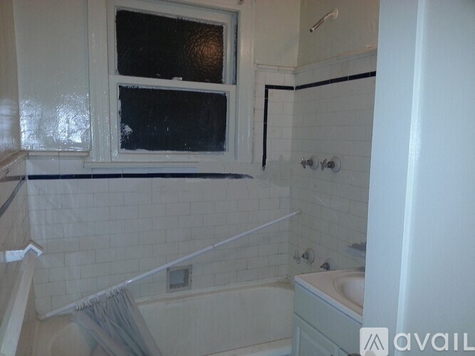 A bathroom with a white tub and a window.