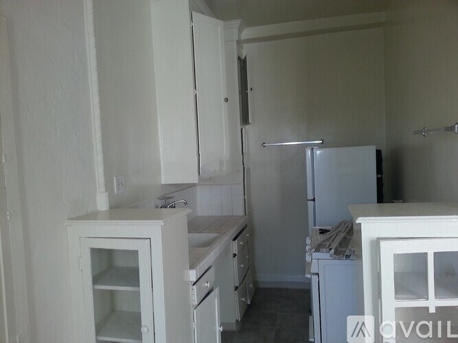 A kitchen with white cabinets and appliances.