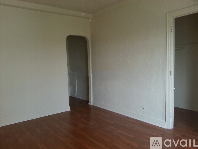 A room with a wooden floor and a door on the right.